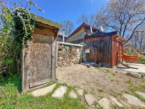 an out house with a wooden door and a building at Ziggiho chalupa in Pliešovce
