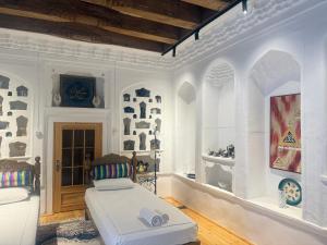 a white bedroom with a bed in a room at Barlos Boutique XVIII in Bukhara