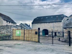 a fence in front of a building with a gate at Ferme de Filot 3 in Hamoir