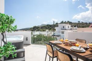 a table on a balcony with a view of the city at Aegora Residence in Kalithies