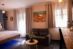 a room with a bed and a couch and a table at Maison Caliya in Saint-Didier-en-Velay