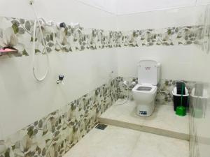 a bathroom with a toilet and a shower at MOMS Villa in Arugam Bay