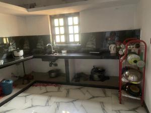 a kitchen with a counter and a table with pots and pans at MOMS Villa in Arugam Bay +28 photos