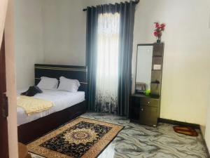 a bedroom with a bed and a dresser and a mirror at MOMS Villa in Arugam Bay