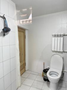 a white bathroom with a toilet in a room at Barlos Boutique XVIII in Bukhara +8 photos