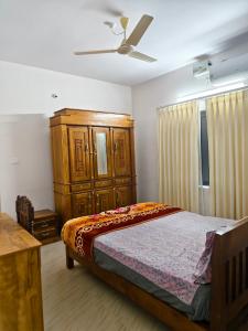 a bedroom with a bed and a wooden cabinet at Periyarhills 2 BHK Budget villa Thekkady in Thekkady