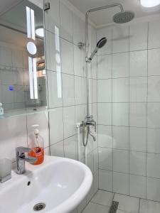 a white bathroom with a sink and a shower at Barlos Boutique XVIII in Bukhara
