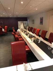 a conference room with a long table and red chairs at Le Vieux Beffroi in Béthune