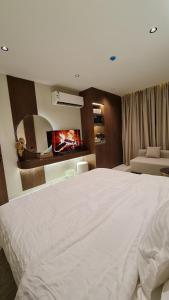 a bedroom with a large white bed and a couch at شقق ضيافة خاصه خدمة ذاتية in Buraydah