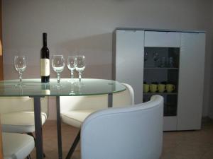 a glass table with a bottle of wine and wine glasses at Apartment Monika in Rovinj