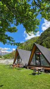 a cabin with tables and chairs in the grass at Thethi Sky Lodge in Theth