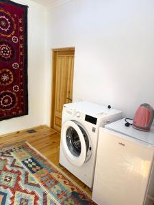 a washing machine in a room with a rug at Barlos Boutique XVIII in Bukhara