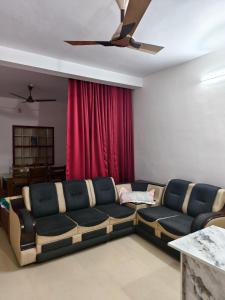 a living room with a couch and a red curtain at Periyarhills 2 BHK Budget villa Thekkady in Thekkady
