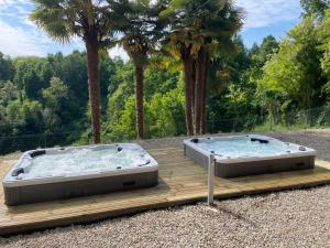two hot tubs sitting on a wooden deck at Oasi del Silenzio a Piea in Piea