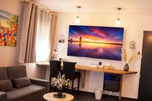 a living room with a large flat screen tv on the wall at Maison Caliya in Saint-Didier-en-Velay