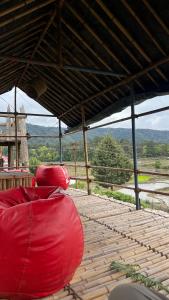 two red bean bags sitting on a wooden deck at Tani Adventure in Ziro