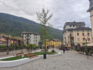 a town with buildings and a tree on a street at Il Rosone in Tirano