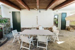 a wooden table and chairs on a patio at Casa Levante - 3 camere, veranda e vista mare in Stintino