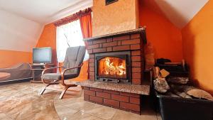 a living room with a brick fireplace and a television at Agroturystyka Düsselkamp Tumiany in Barczewo +7 photos