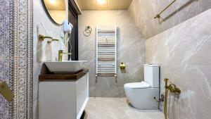 a bathroom with a white toilet and a sink at Eastlight Cottage in Gorists'ikhe +17 photos