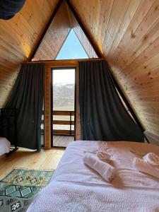 a bed in a room with a large window at Eastlight Cottage in Gorists'ikhe