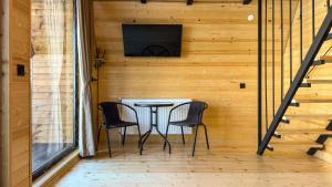 a table and chairs on a porch with a television at Eastlight Cottage in Gorists'ikhe