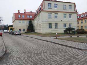 a cobblestone street in front of a large building at Baza Ślęża , Nowoczesny Apartament w sercu Sobótki in Sobótka