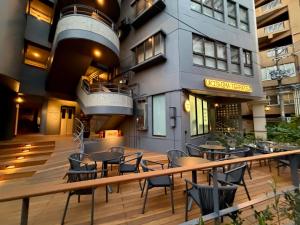 a balcony with tables and chairs in front of a building at Kokusai Towns Inn in Naha