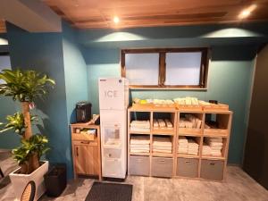 a room with a refrigerator and a shelf with towels at Kokusai Towns Inn in Naha