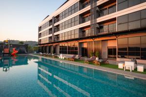 a swimming pool in front of a building at GrandWara Khao Yai แกรนด์วารา เขาใหญ่ in Ban Nong Song Hong
