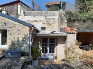 an old stone house with a large door at TROGLODYTE - La Grotte d'Auré in Le Puy-Notre-Dame