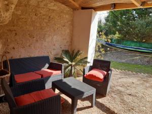 a patio with chairs and a table and a hammock at TROGLODYTE - La Grotte d'Auré in Le Puy-Notre-Dame +6 photos