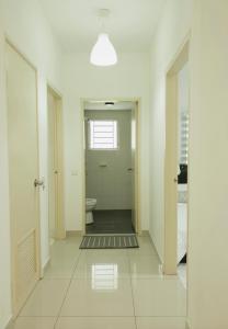 a white hallway with a toilet and a door at AmyHana Cozynest in Putrajaya
