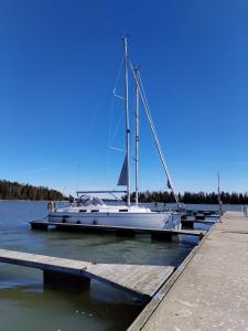 a sailboat docked at a dock in the water at Spend a night on a Sailing Boat in Saltvik