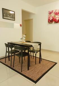 a dining room table and chairs on a rug at AmyHana Cozynest in Putrajaya +10 photos