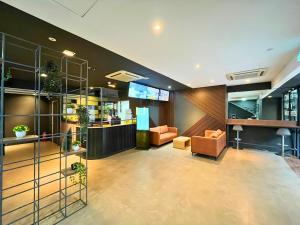 a lobby of a building with chairs and a bar at Sky Hotel Cheras Maluri in Kuala Lumpur