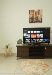 a flat screen tv sitting on top of a wooden stand at AmyHana Cozynest in Putrajaya