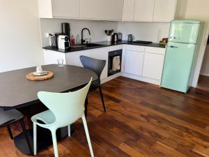 a kitchen with a table and chairs and a refrigerator at Vue imprenable Léman - Cosy à Chexbres in Chexbres