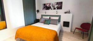 a bedroom with a bed and a red chair at La Grange de Junas in Junas +24 photos