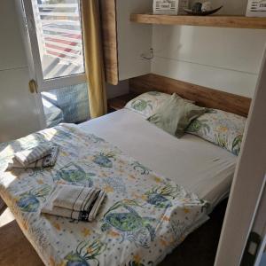 a small bedroom with a bed and a window at Mobile Homes Albatross in Pirovac +45 photos