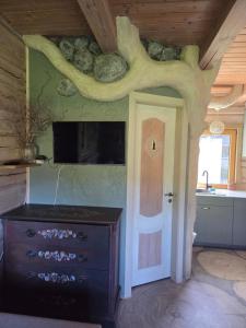 a room with a kitchen with a tree branch on the wall at Sodyba Atgaiva in Lazdininkai +26 photos