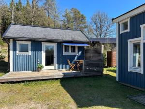 a blue tiny house with a wooden porch at Boende nära sjö i Gyltige Simlångsdalen in Simlångsdalen