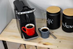 a coffee maker with two cups of coffee on a table at Le Monde Luxury Apartment in Turin +8 photos