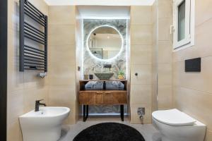 a bathroom with a sink and a toilet and a mirror at Le Monde Luxury Apartment in Turin