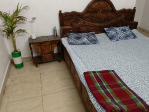 a bedroom with a bed and a potted plant at Hotel Vasu in Gopālganj