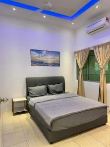 a bedroom with a bed with a blue ceiling at Howie Home in Ipoh