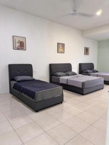 two beds in a room with two bedsitures at Howie Home in Ipoh