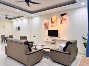 a waiting room at a clinic with chairs and a tv at Howie Home in Ipoh