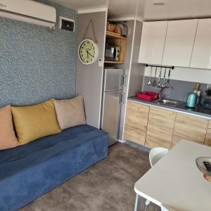 a living room with a blue couch in a kitchen at Mobile Homes Albatross in Pirovac