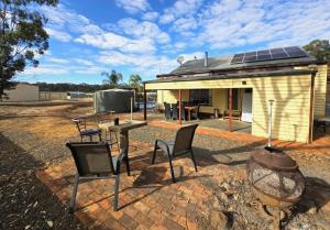 a patio with chairs and a table and a building at Whispering Woods Pool Sauna in Maryborough +13 photos